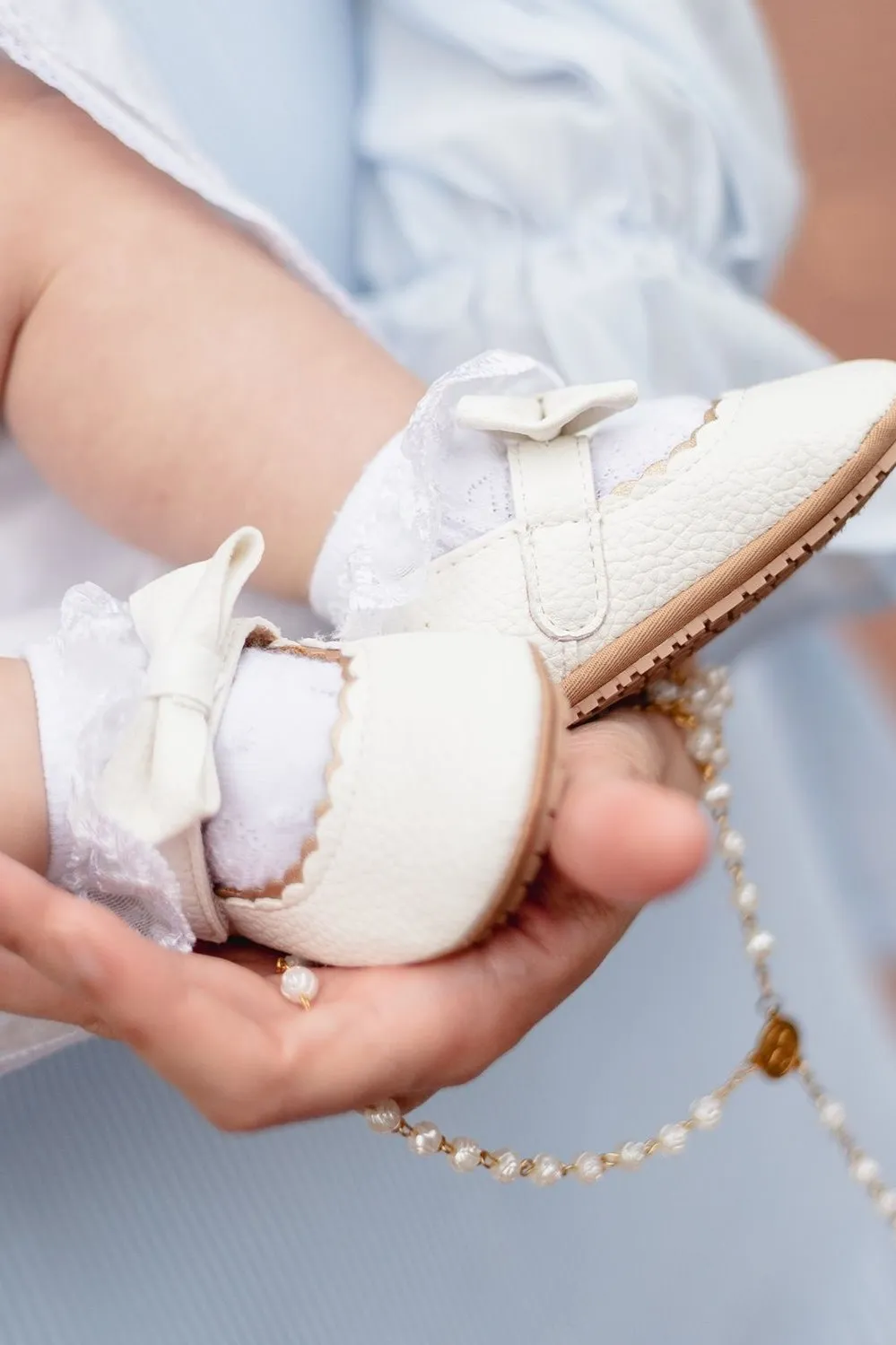 Bebé en bautismo con vela y flores blancas